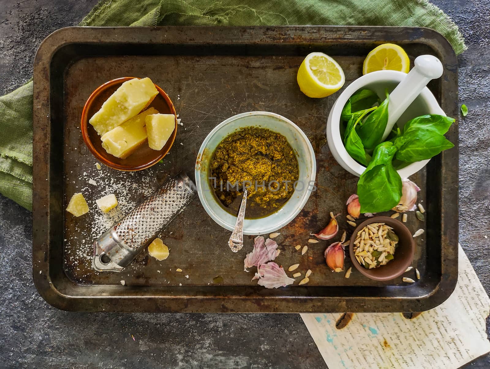 Green pesto, basil in mortar, parmesan cheese, garlic on metal tray by Wierzchu