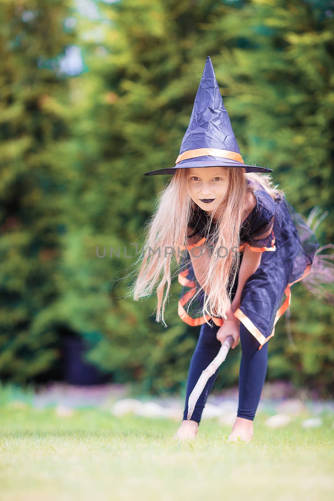 Happy little witch with broom on Halloween. Trick or treat. by travnikovstudio