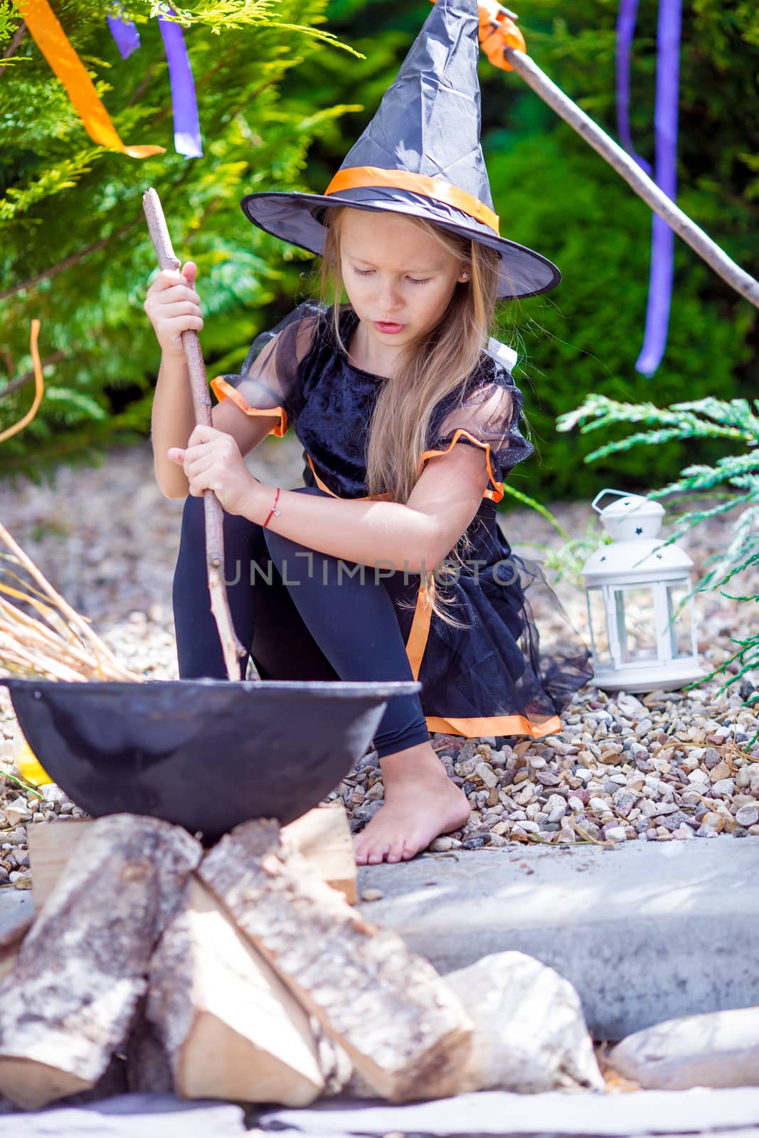 Happy little girl wearing witch costume on Halloween outdoors. Trick or treat. by travnikovstudio