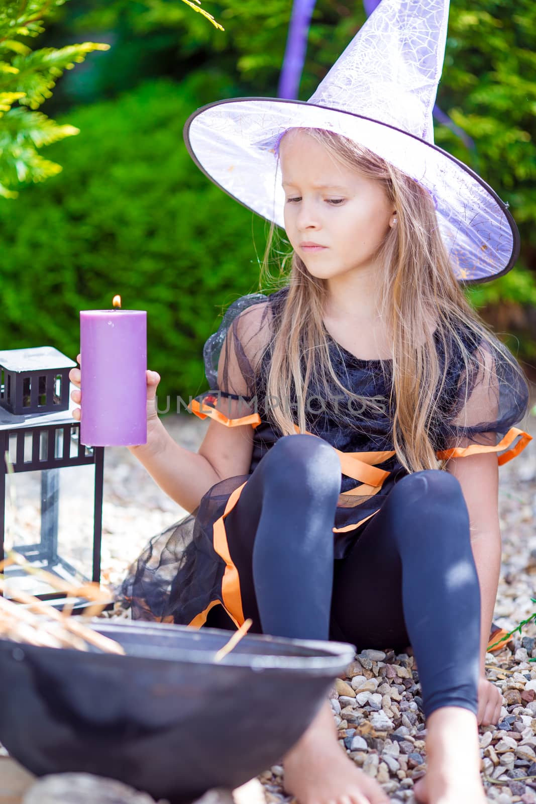 Halloween and adorable little girl dressed as a witch by travnikovstudio