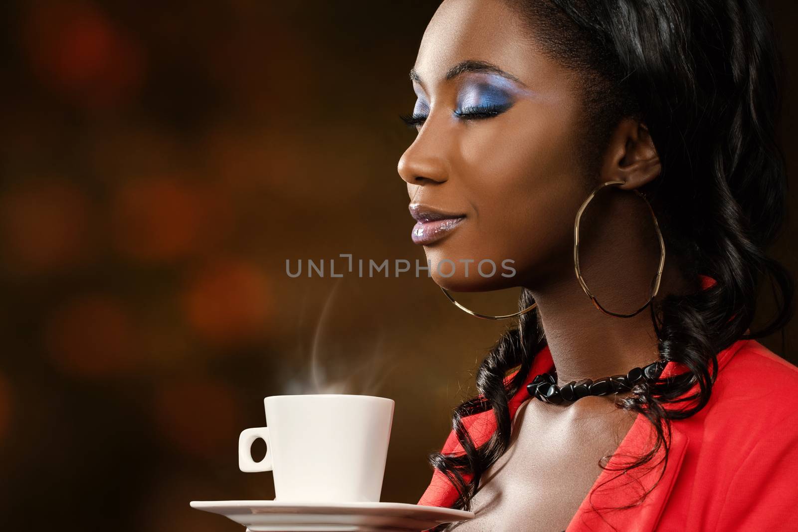 Close up face shot of attractive young african woman smelling coffee aroma with eyes closed.Low key portrait of elegant girl with cosmetic beauty make up. 