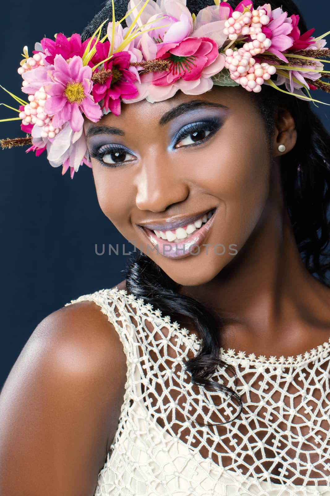 Close up beauty portrait of charming young african bride wearing colorful flower hair wreath.