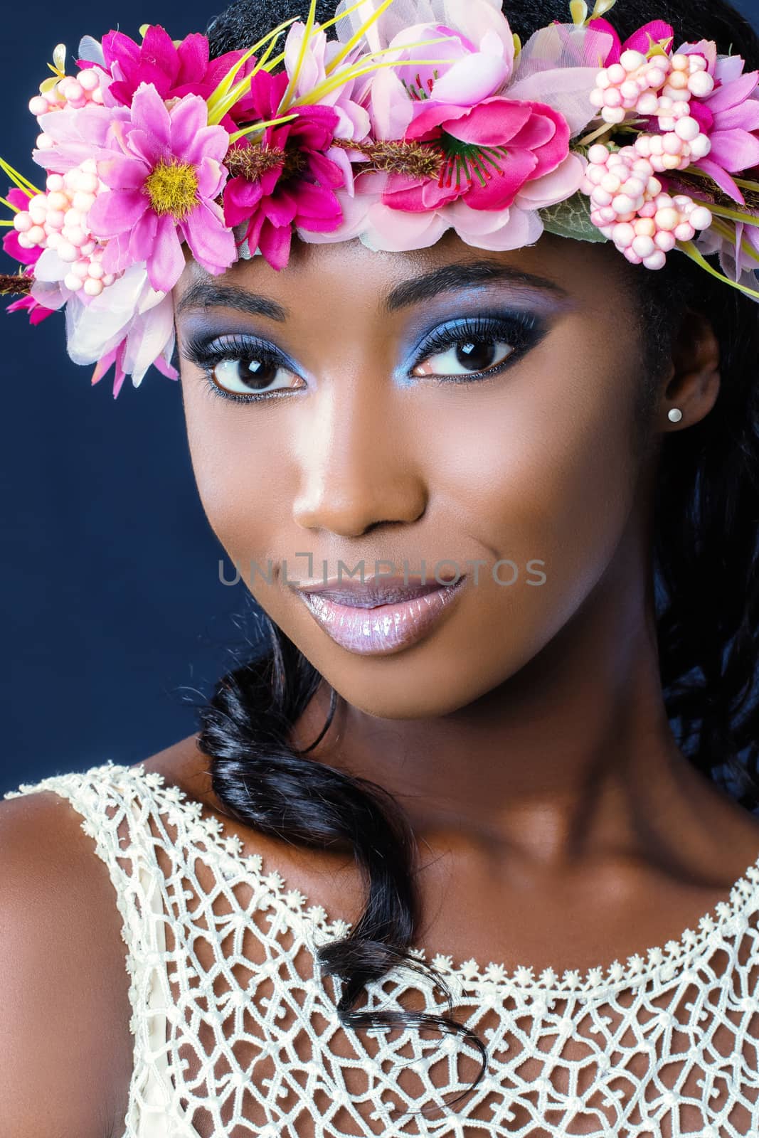 Close up beauty portrait of attractive young african bride wearing colorful flower garland.