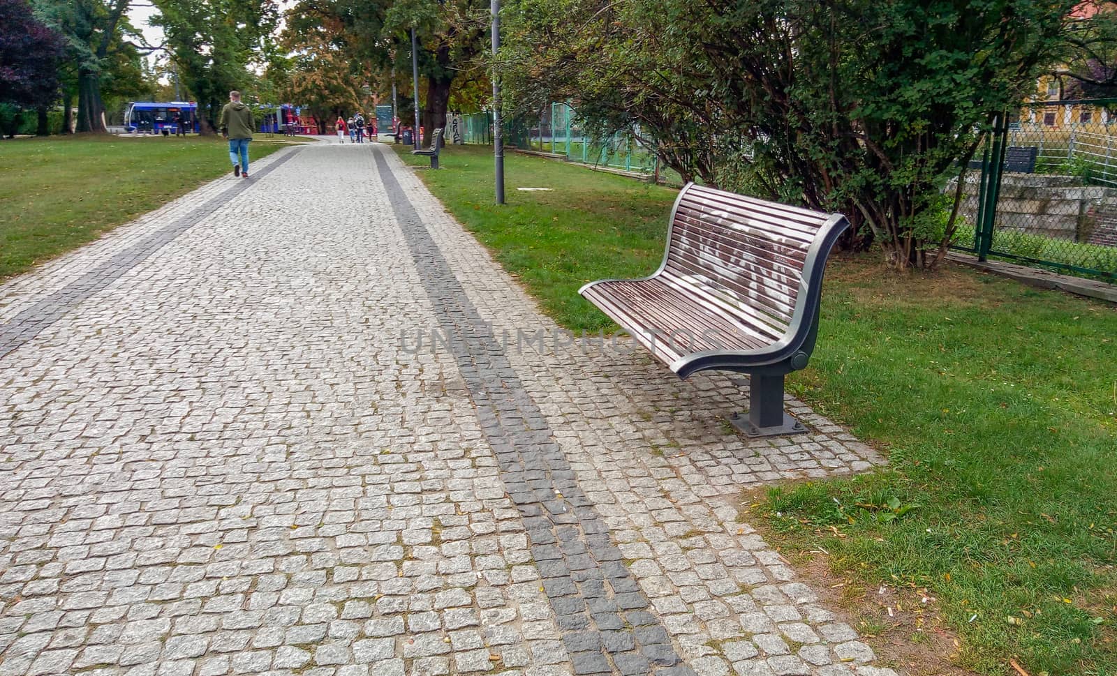 Wooden bench on side of pavement in Wroclaw city by Wierzchu