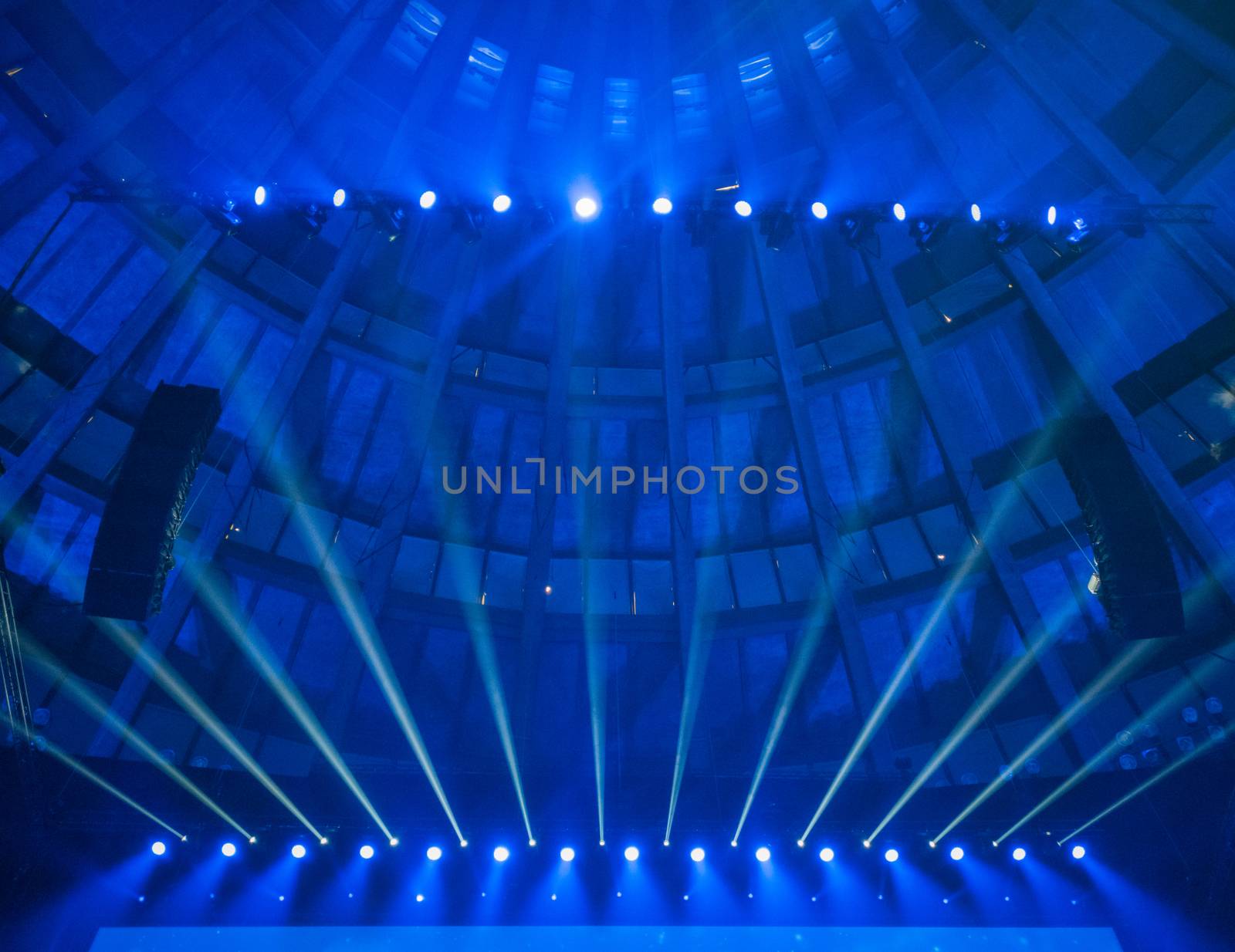 Lookup to ceiling in conference hall with blue lights over screen by Wierzchu