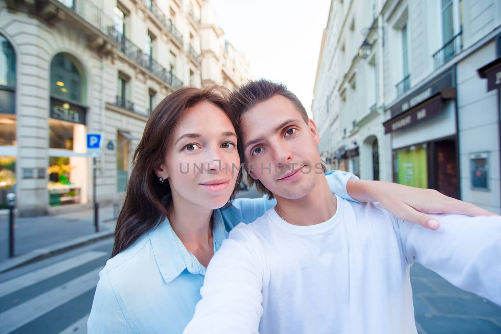 Happy young couple taking selfie in Paris outdoors by travnikovstudio