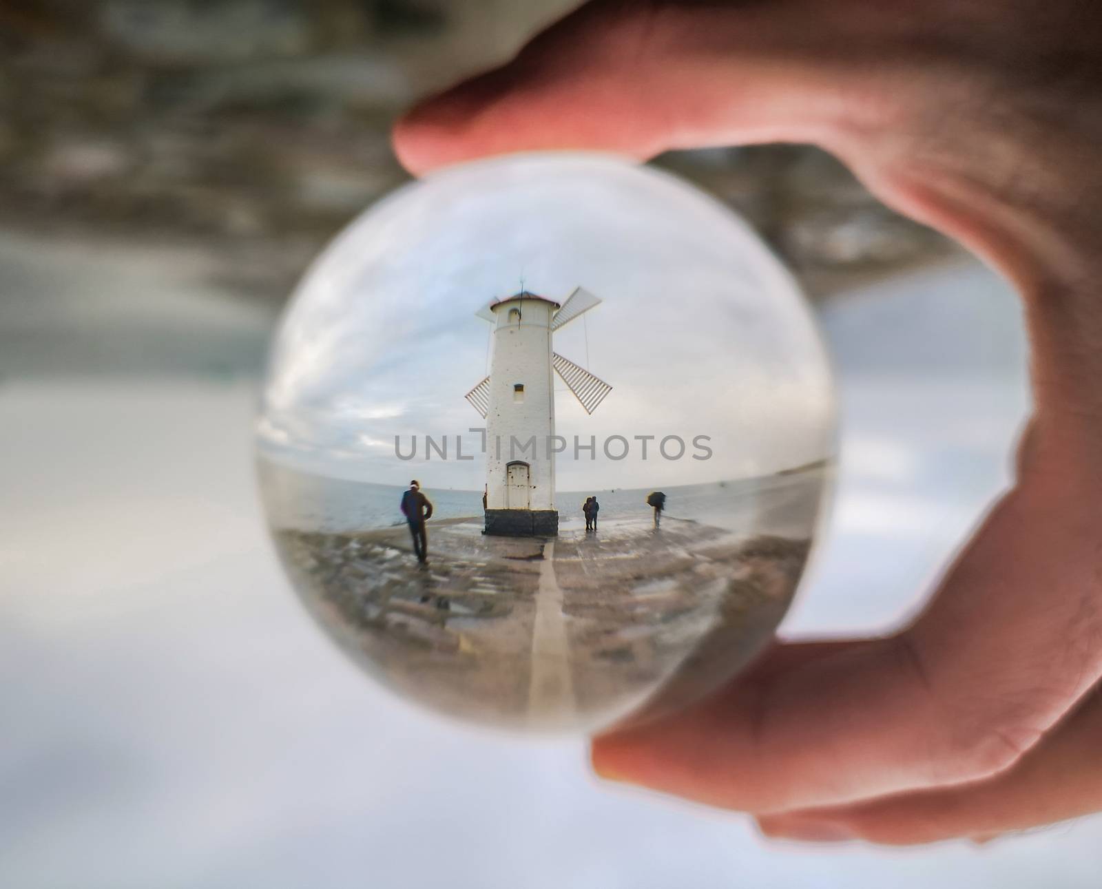 White Windmill at end of coast full of puddles near Baltic sea in Swinoujscie in reflection of crystal ball by Wierzchu