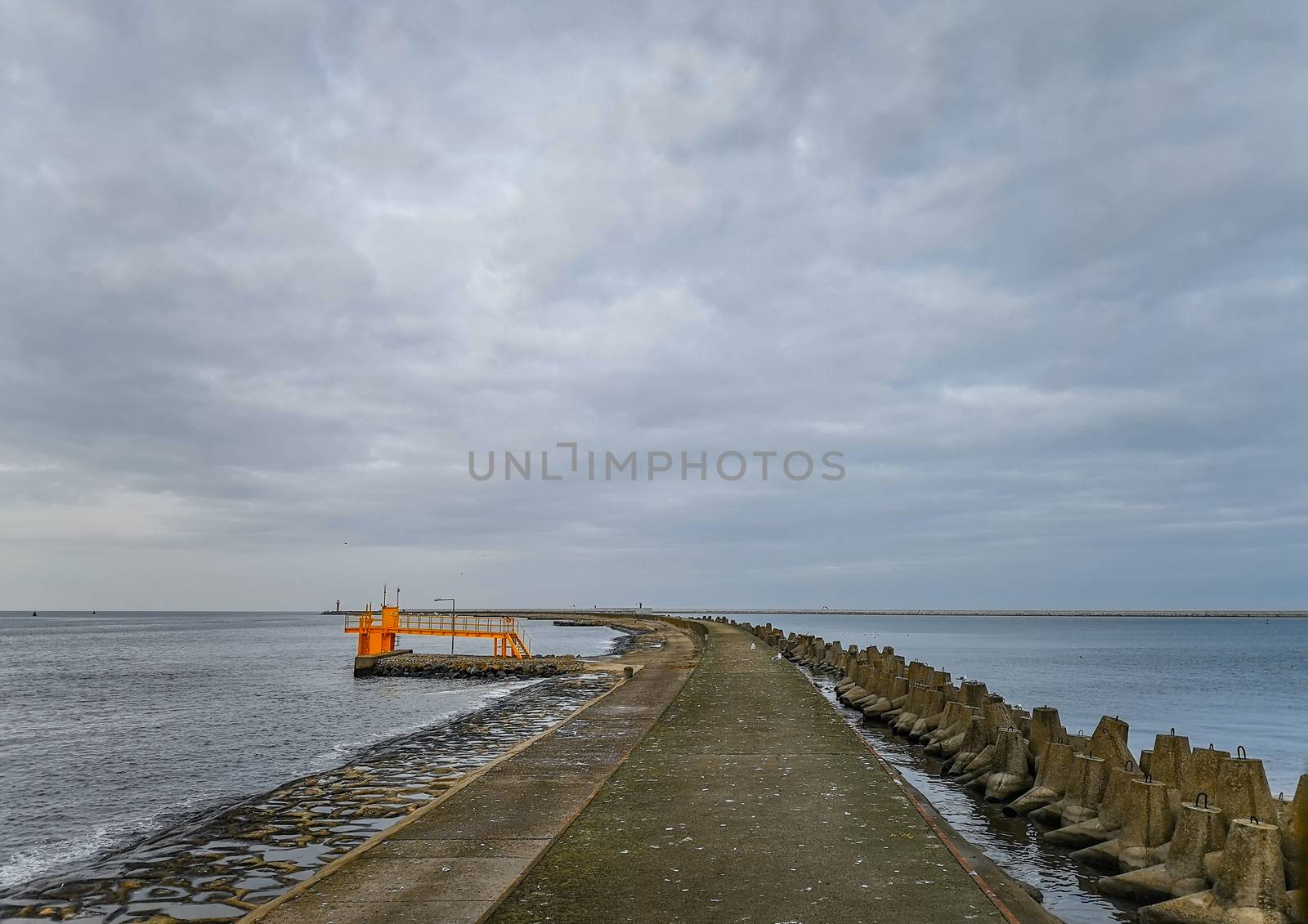 Concrete water pier in Swinoujscie with Baltic sea and breakwaters around by Wierzchu