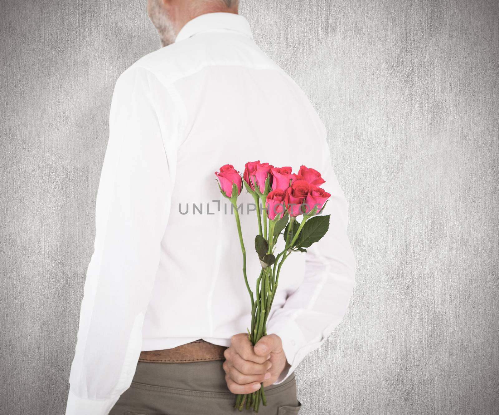 Composite image of man holding bouquet of roses behind back by Wavebreakmedia