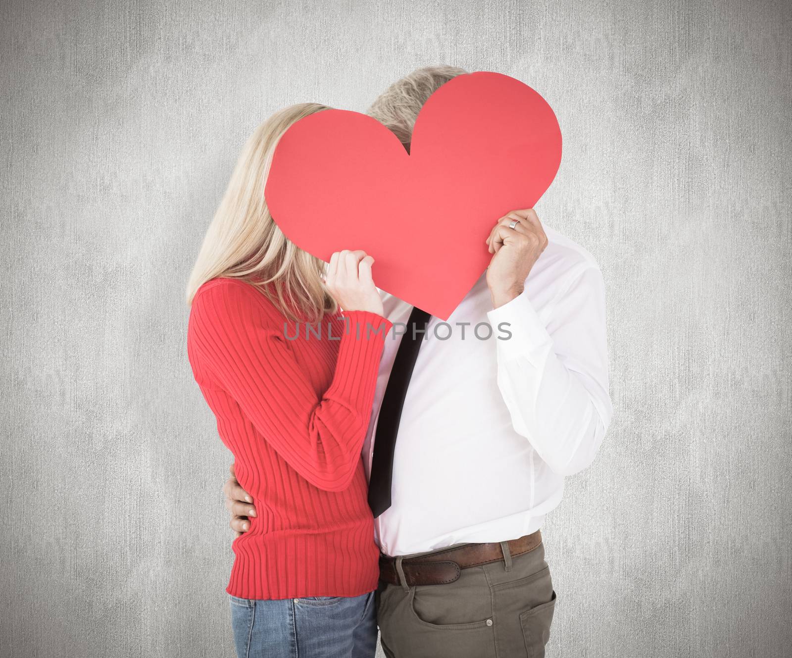 Handsome man getting a heart card form wife against weathered surface 