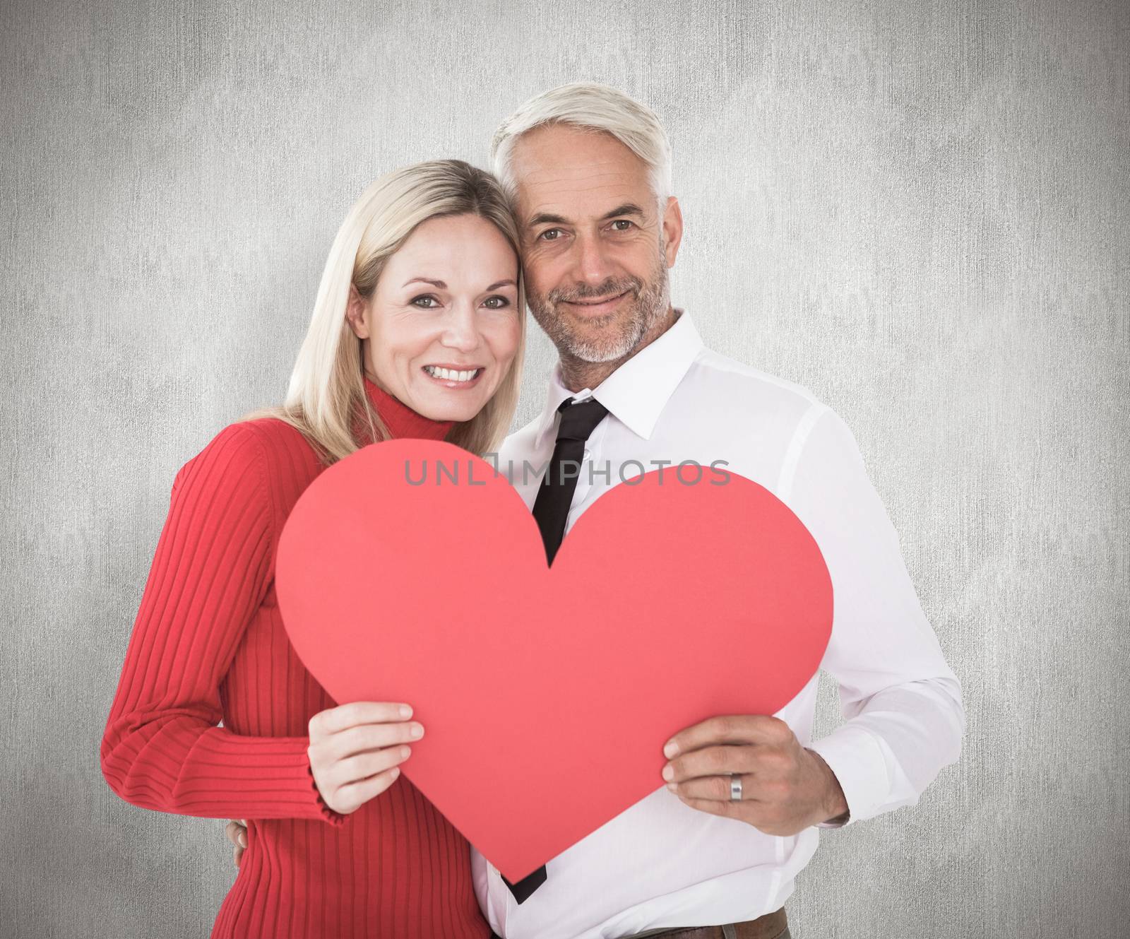 Handsome man getting a heart card form wife against weathered surface 