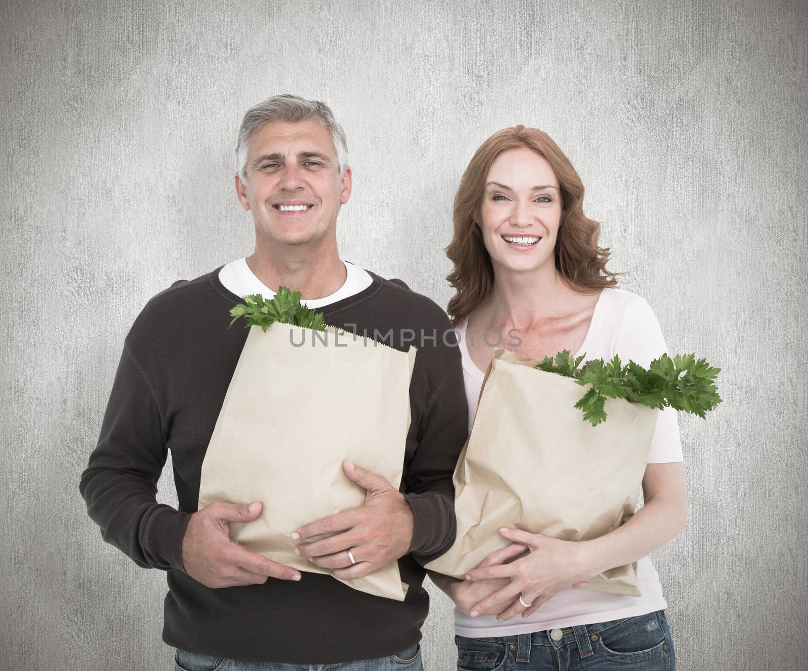 Composite image of casual couple holding grocery bags by Wavebreakmedia