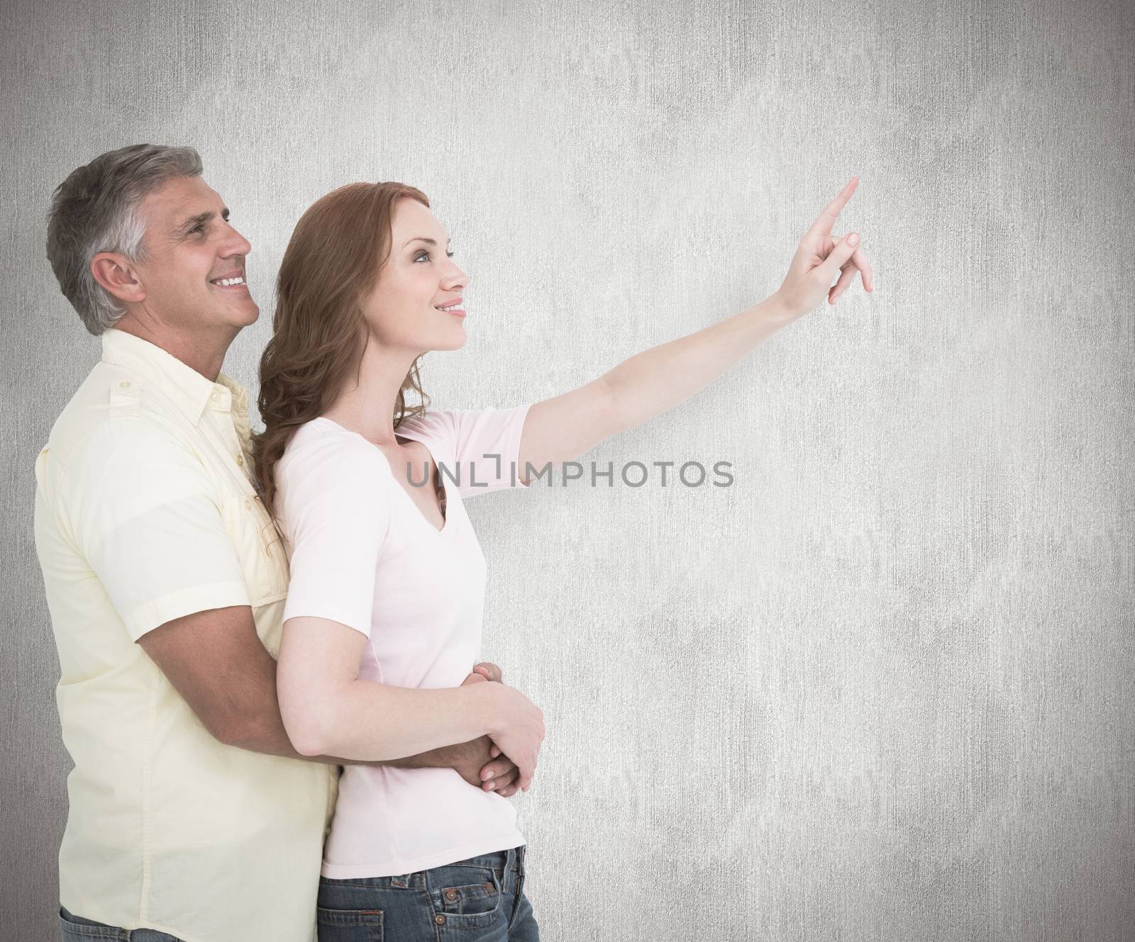 Composite image of casual couple hugging and looking by Wavebreakmedia