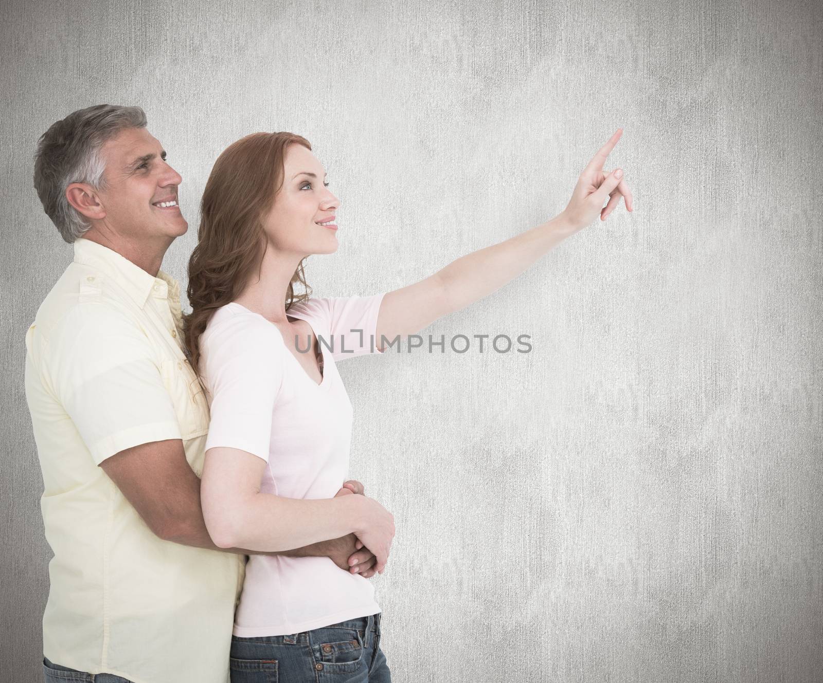 Casual couple hugging and looking against white background