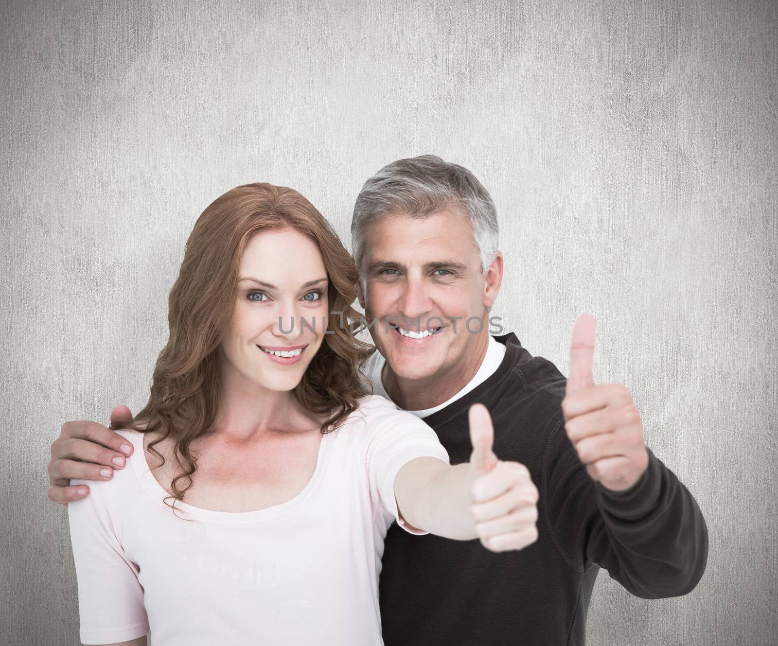 Casual couple showing thumbs up against white background