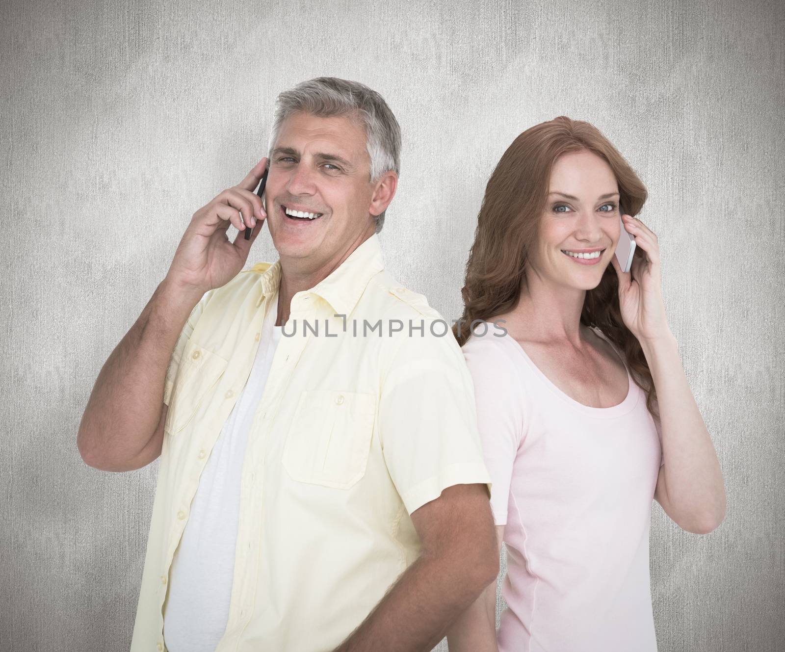 Casual couple on their phones against white background