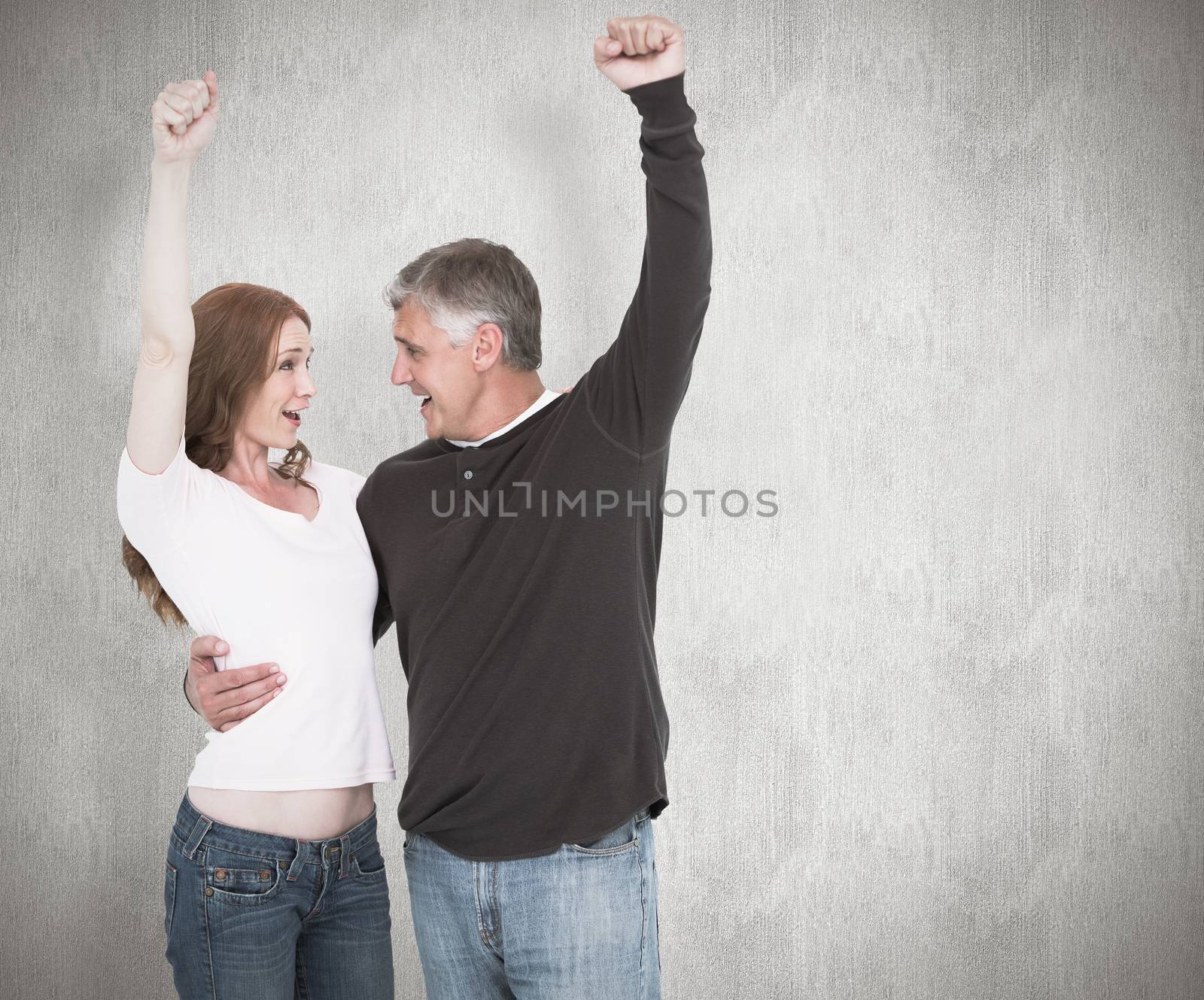 Casual couple cheering and smiling against white background