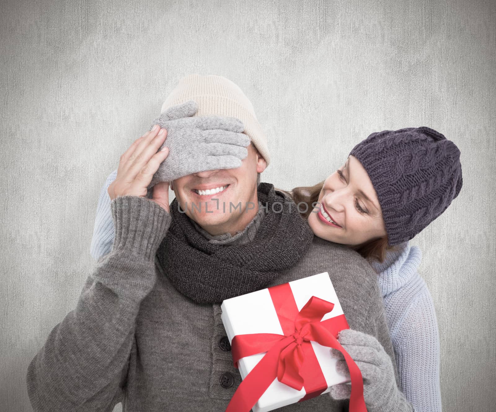 Woman surprising husband with gift against white background