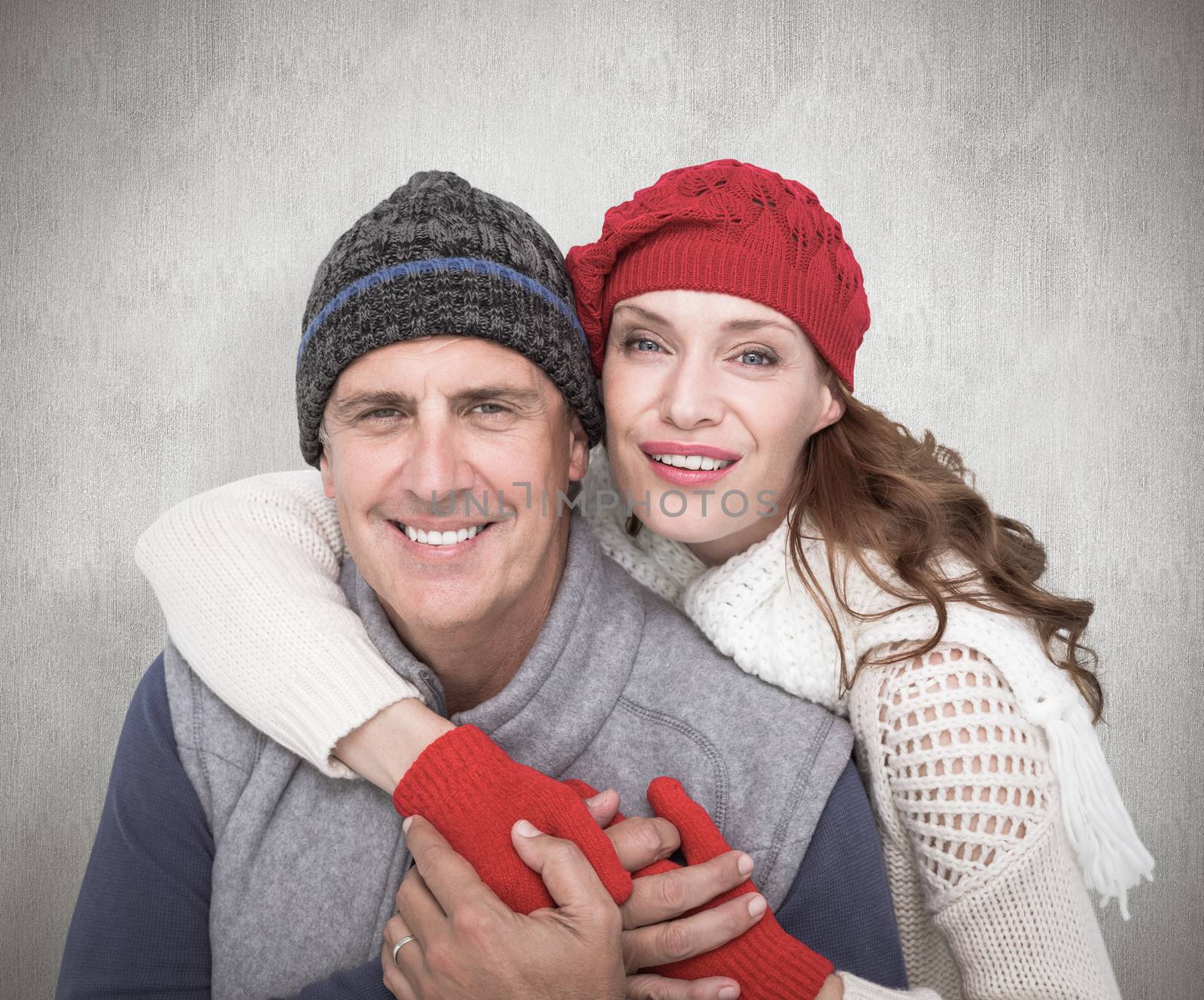 Happy couple in warm clothing against white background