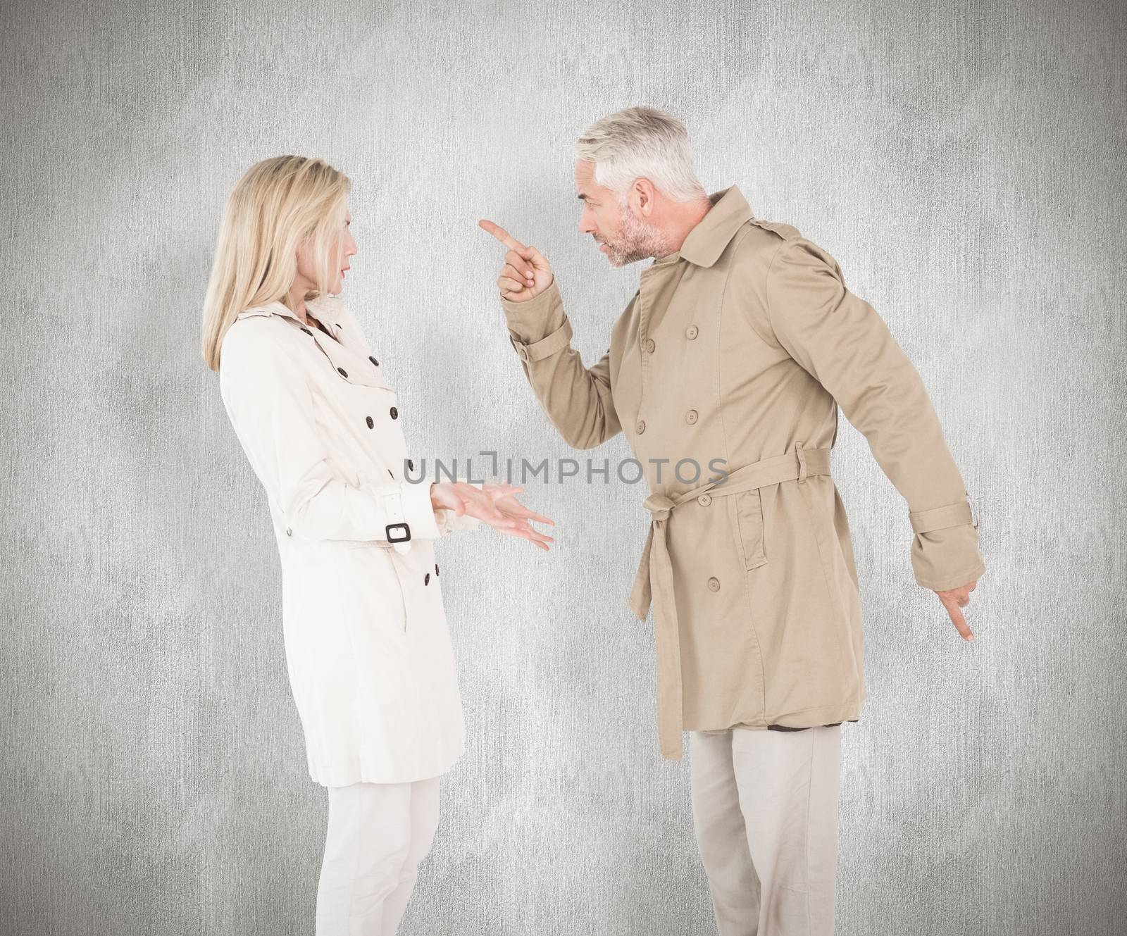 Composite image of angry couple fighting in trench coats by Wavebreakmedia