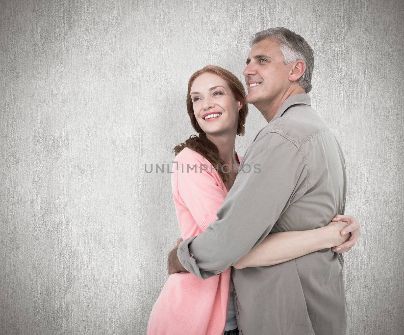 Casual couple hugging and smiling against white background