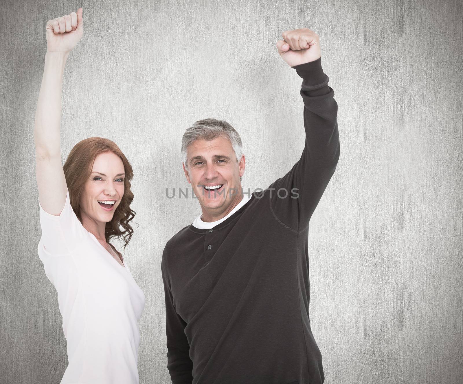 Composite image of casual couple cheering at camera by Wavebreakmedia
