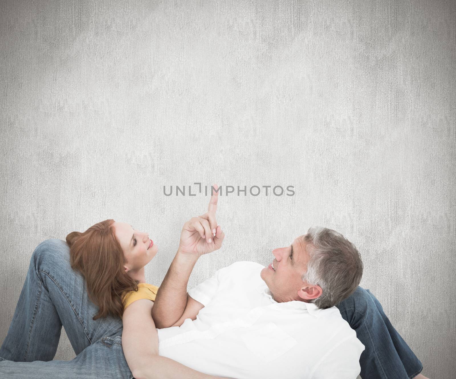 Composite image of casual couple lying on floor by Wavebreakmedia