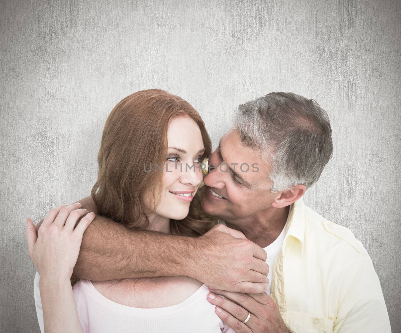 Casual couple smiling and hugging against white background