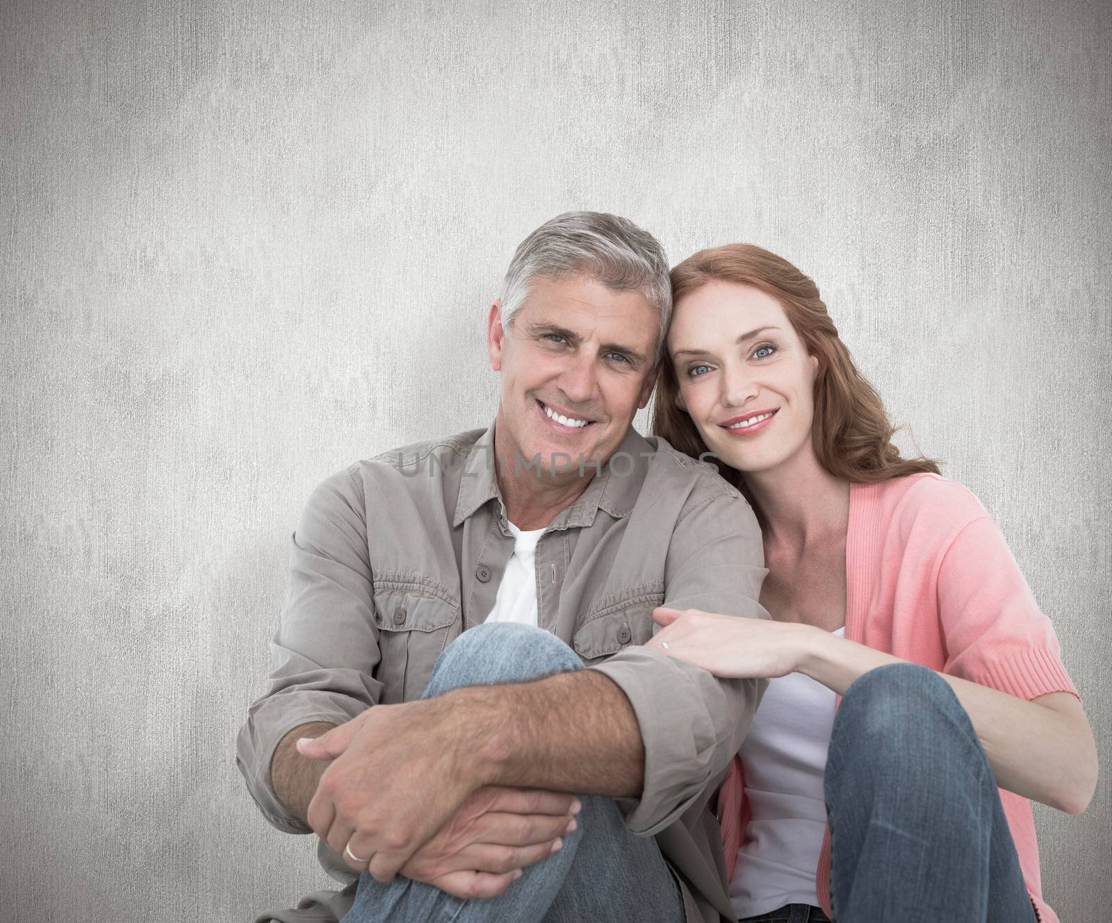 Casual couple sitting and smiling against white background