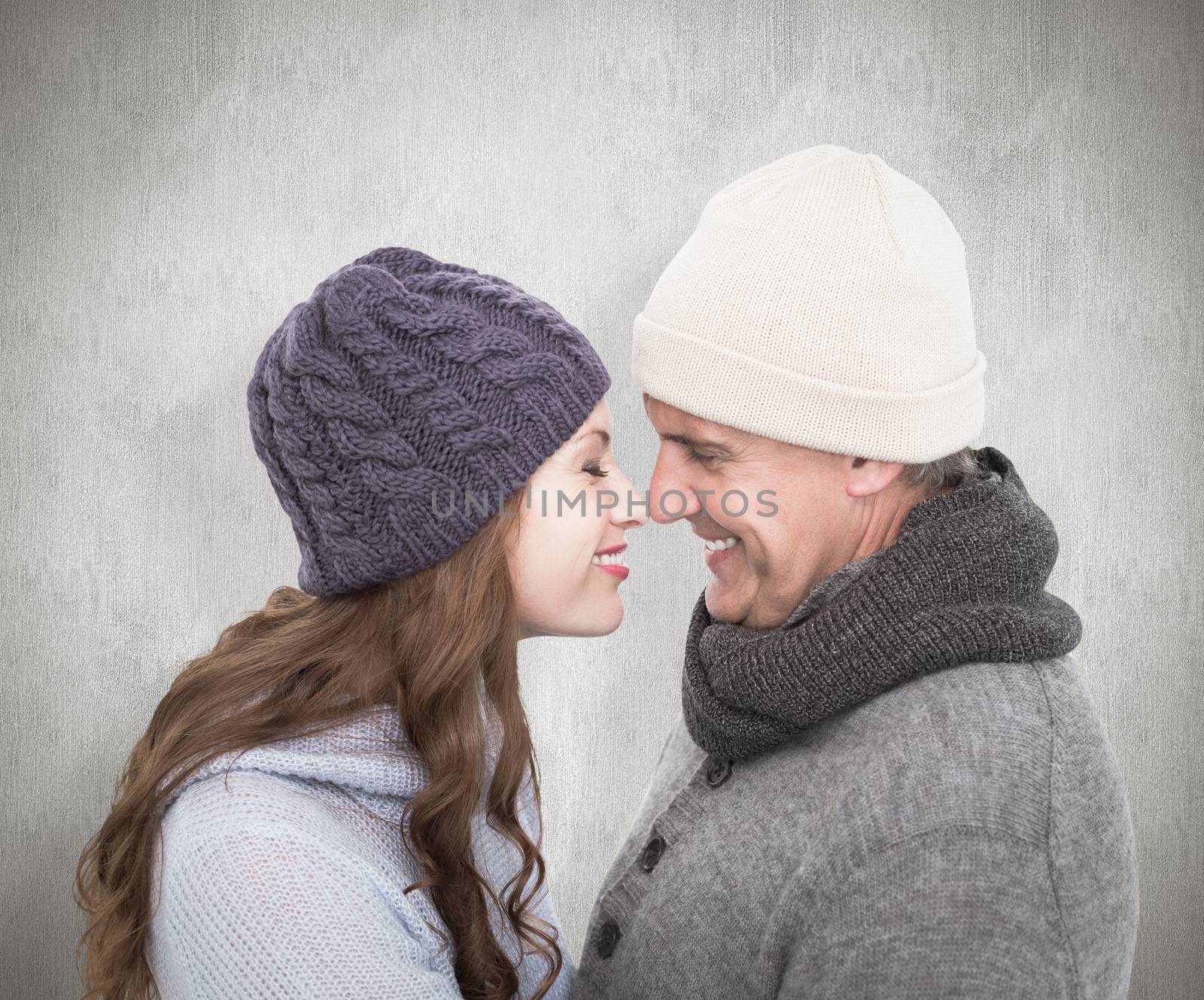 Couple in warm clothing facing each other against white background