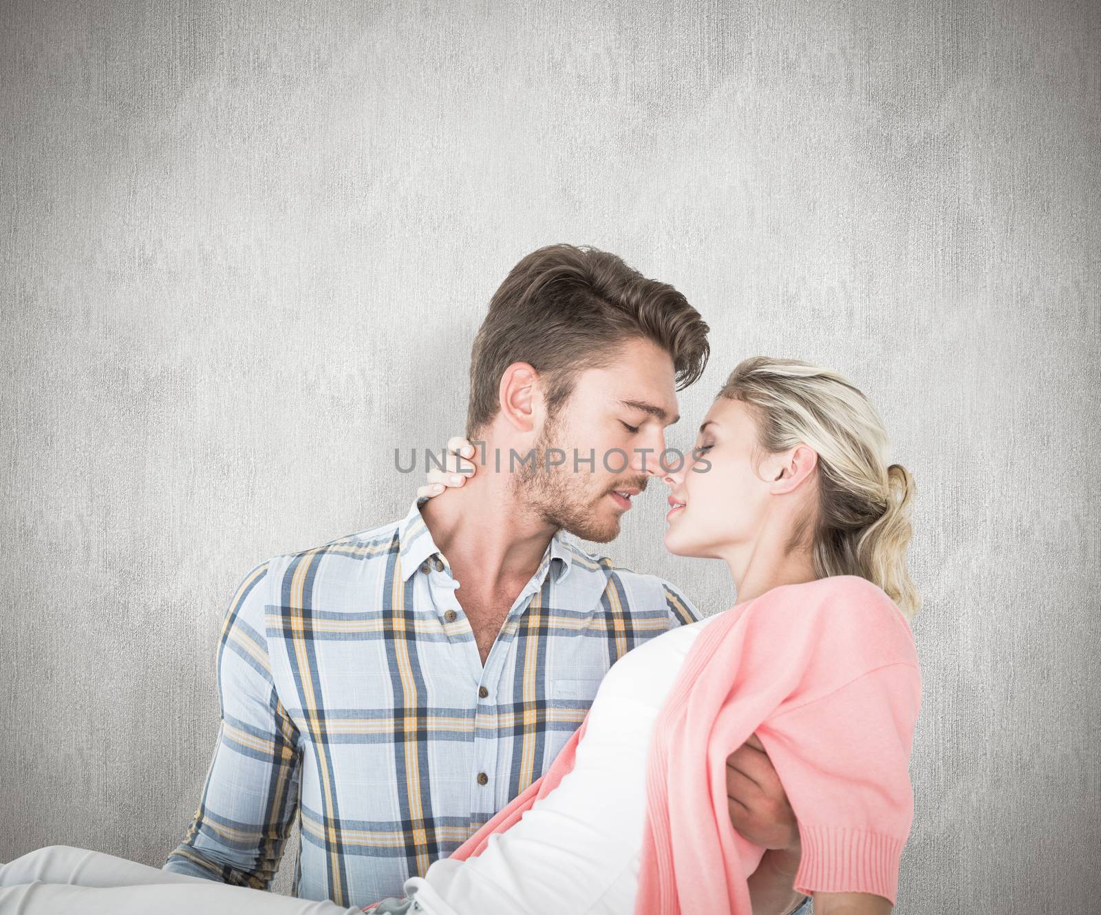 Handsome man picking up and hugging his girlfriend against white background