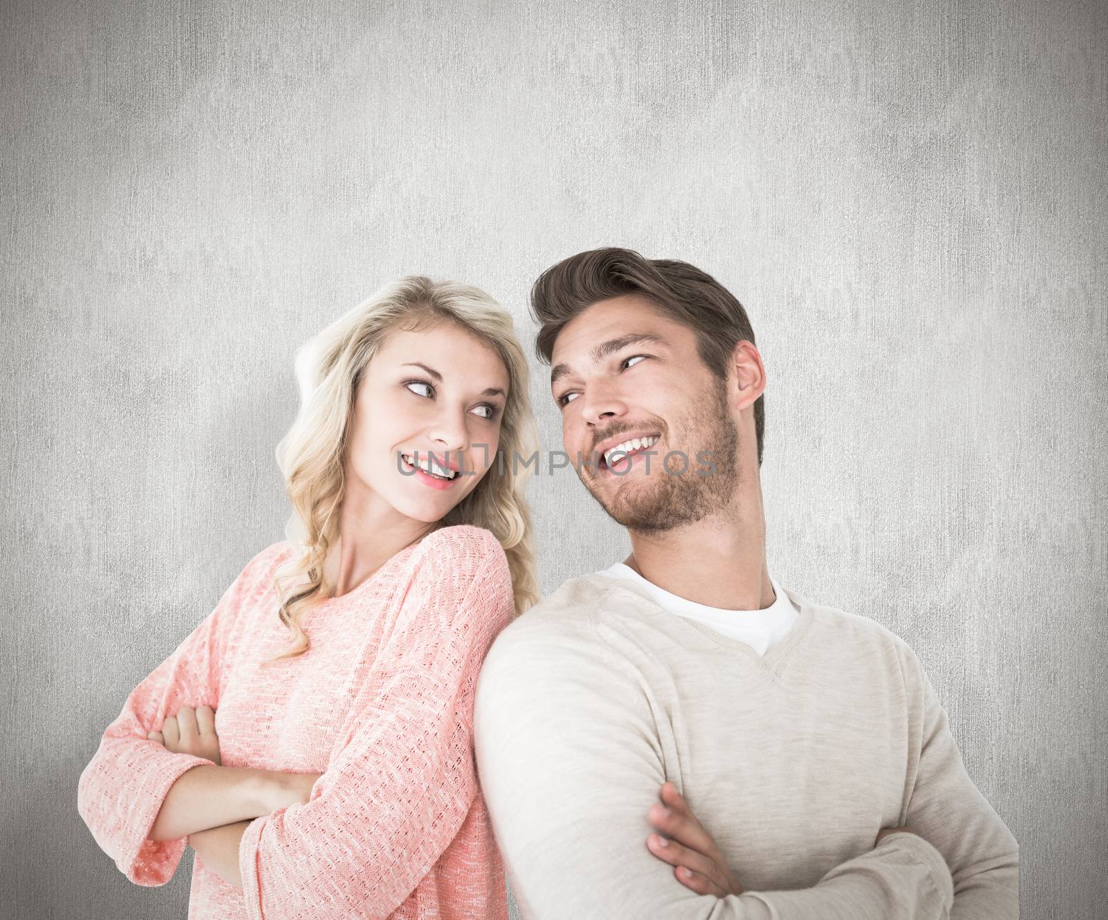 Attractive couple smiling with arms crossed against white background