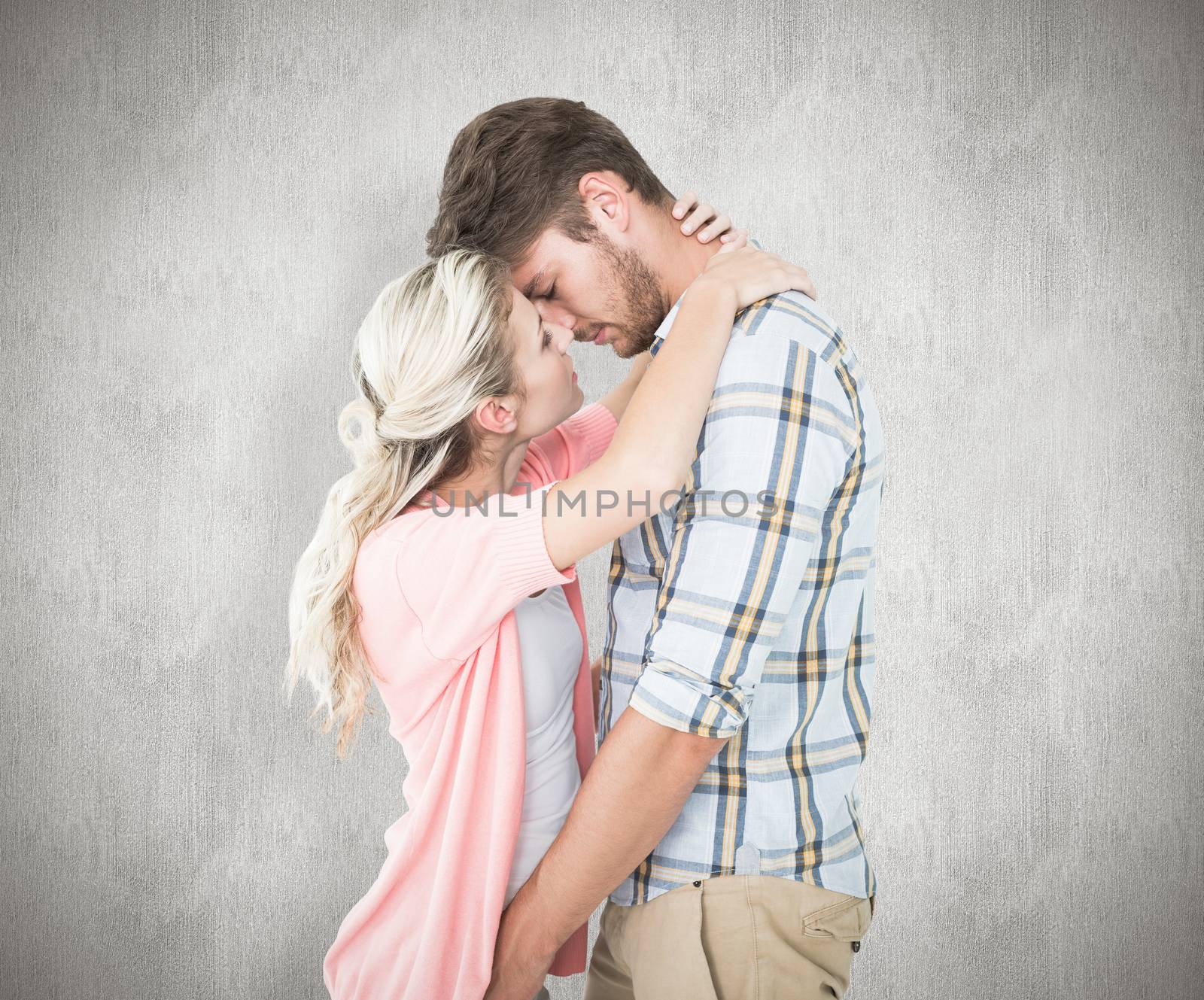 Attractive young couple about to kiss against white background