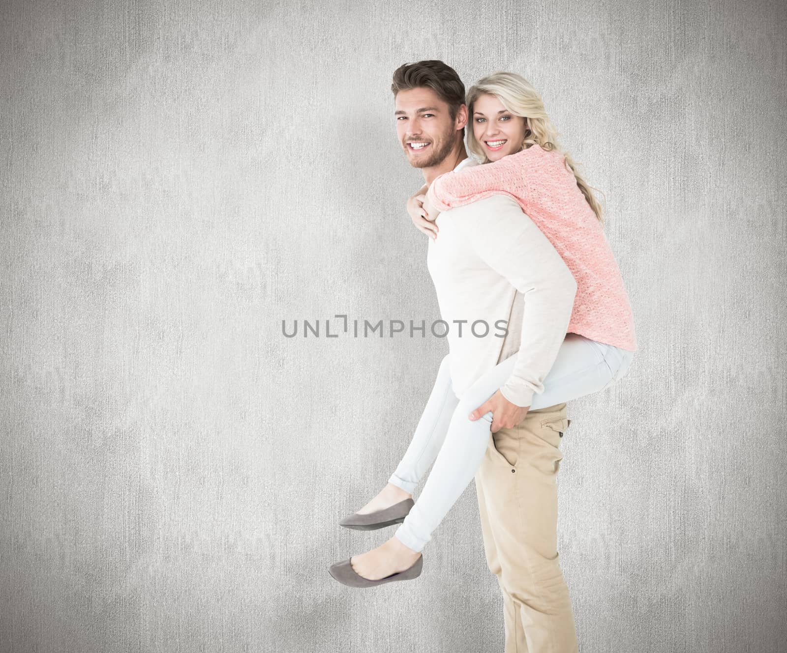 Handsome man giving piggy back to his girlfriend against white background