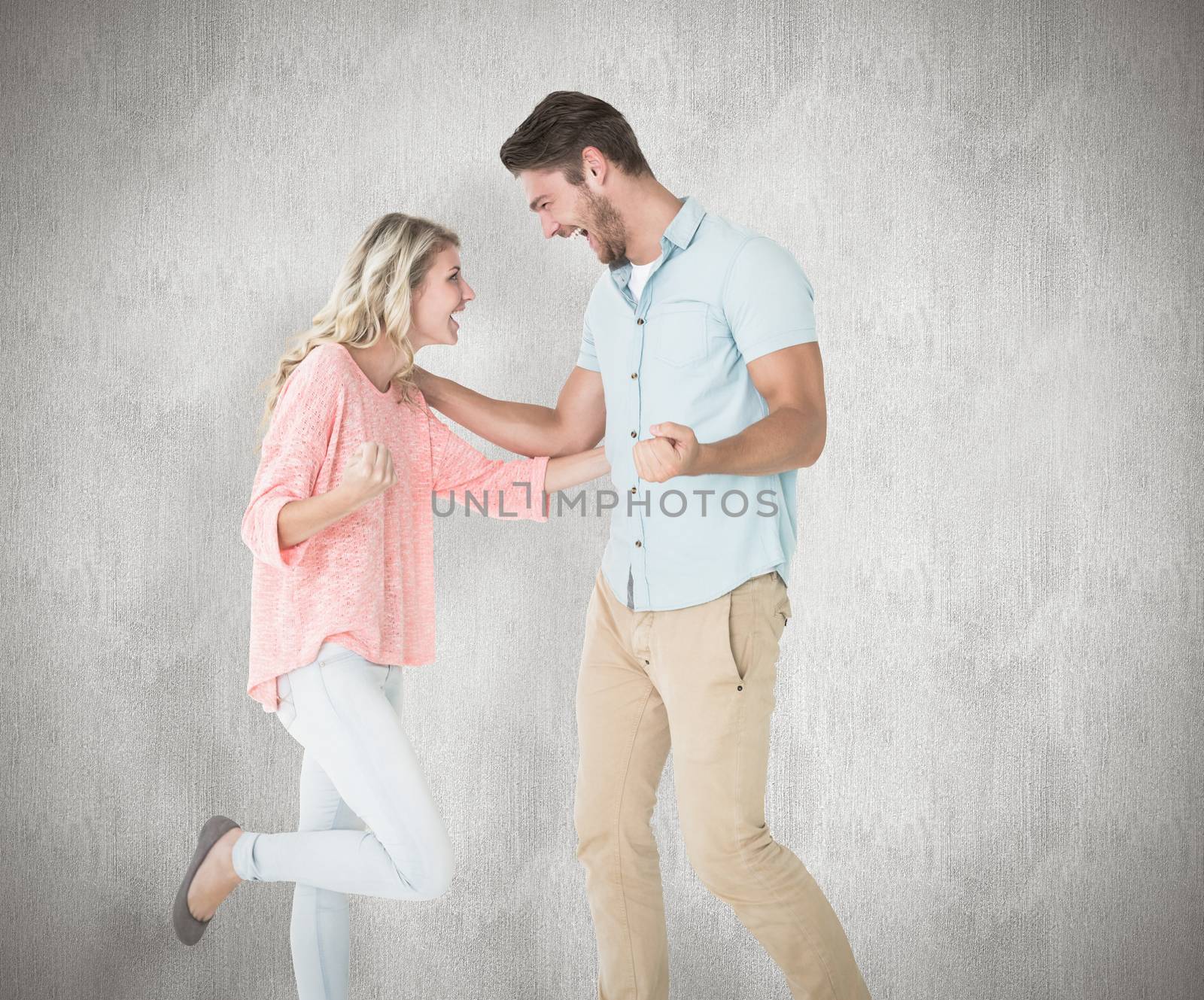 Attractive couple smiling and cheering against white background