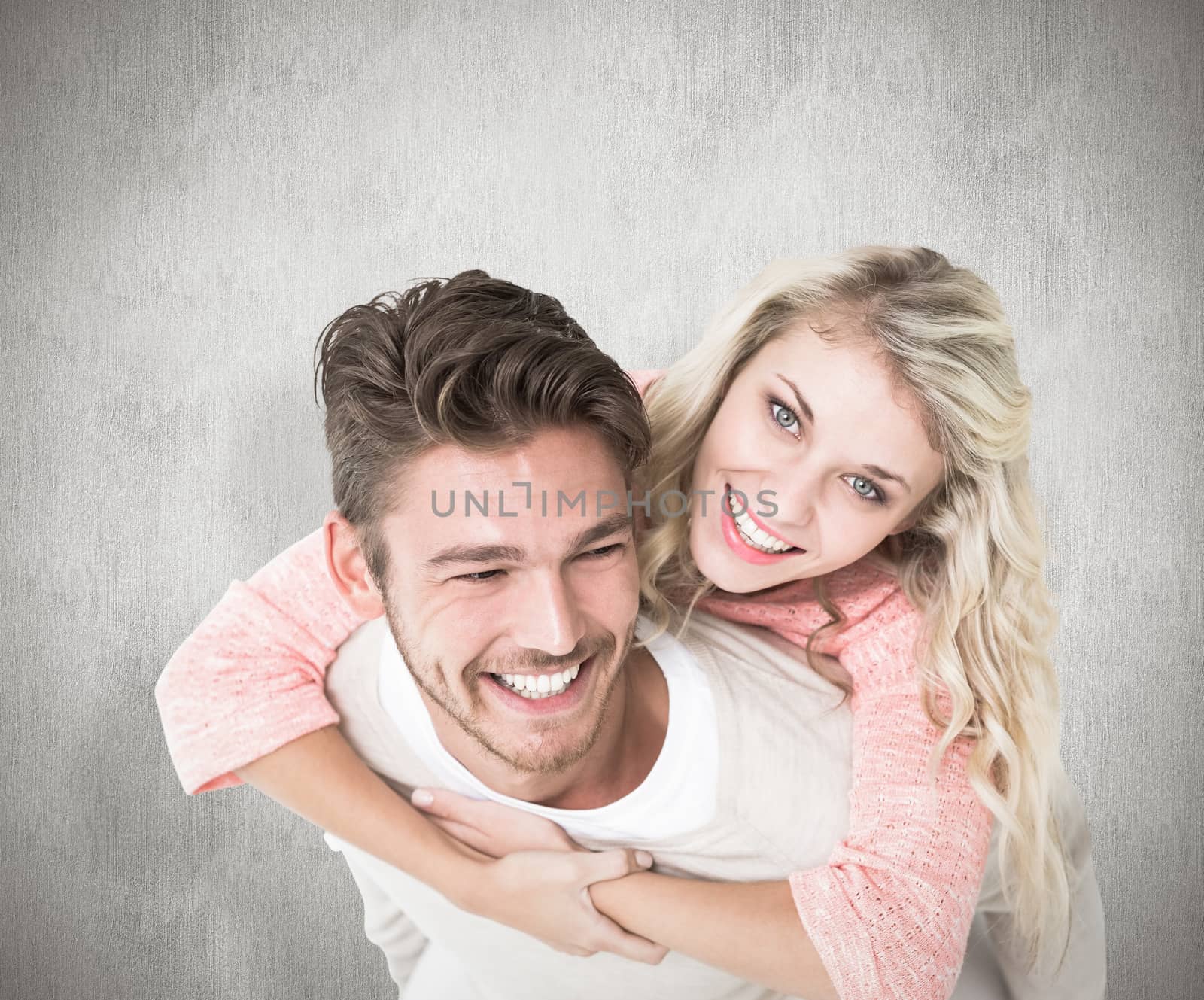 Handsome man giving piggy back to his girlfriend against white background