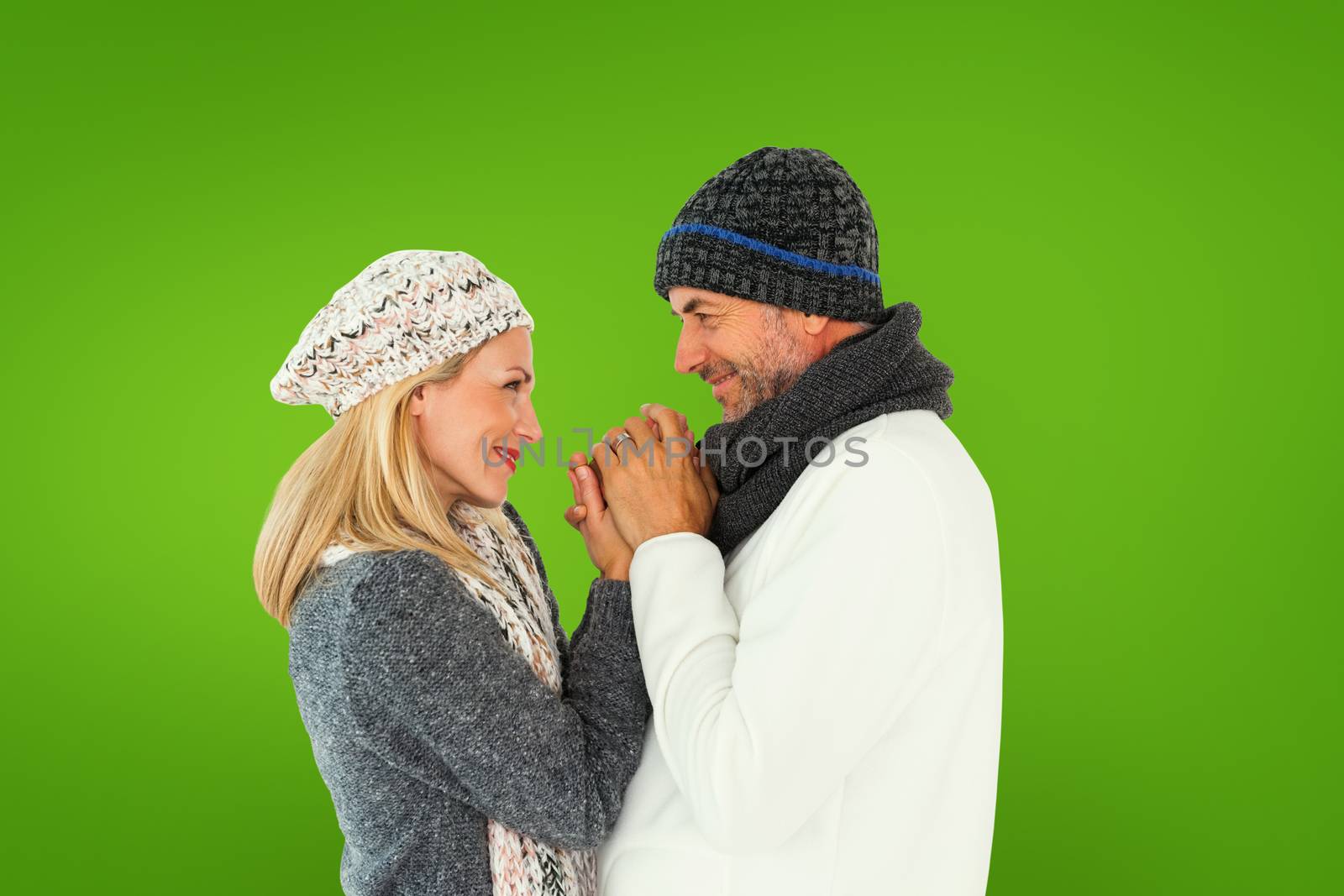 Couple in winter fashion embracing against green vignette