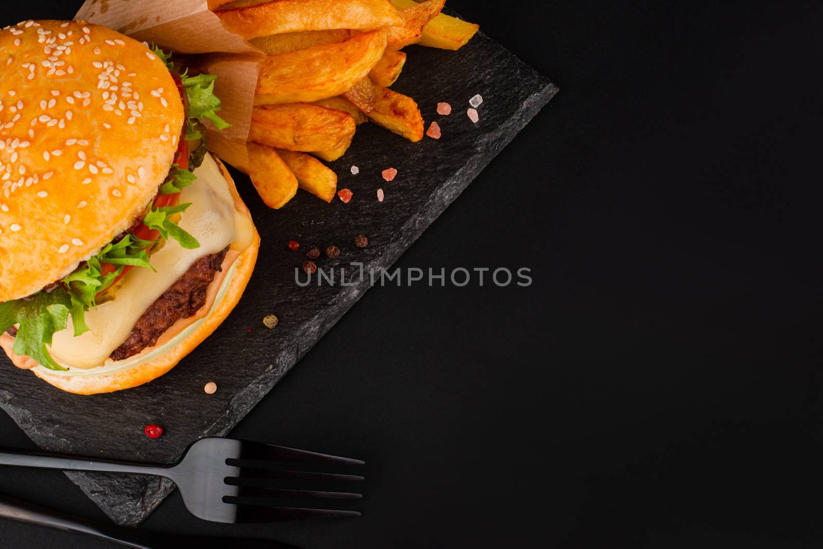Hamburger with french fries on black by destillat