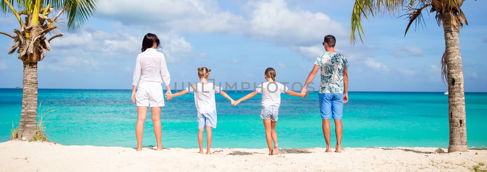 Young family on vacation on the beach by travnikovstudio