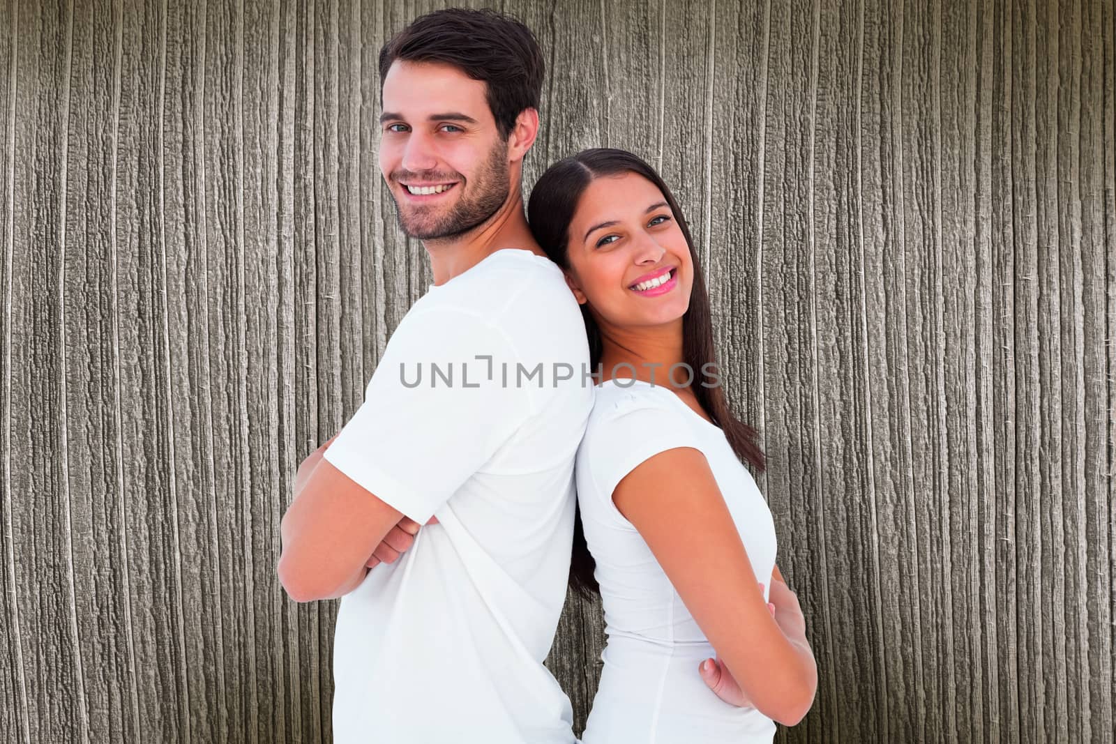 Happy couple smiling at camera against wooden planks