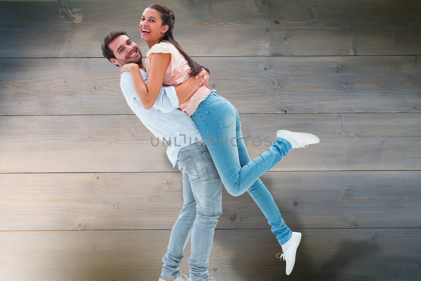 Attractive young couple hugging each other against bleached wooden planks background