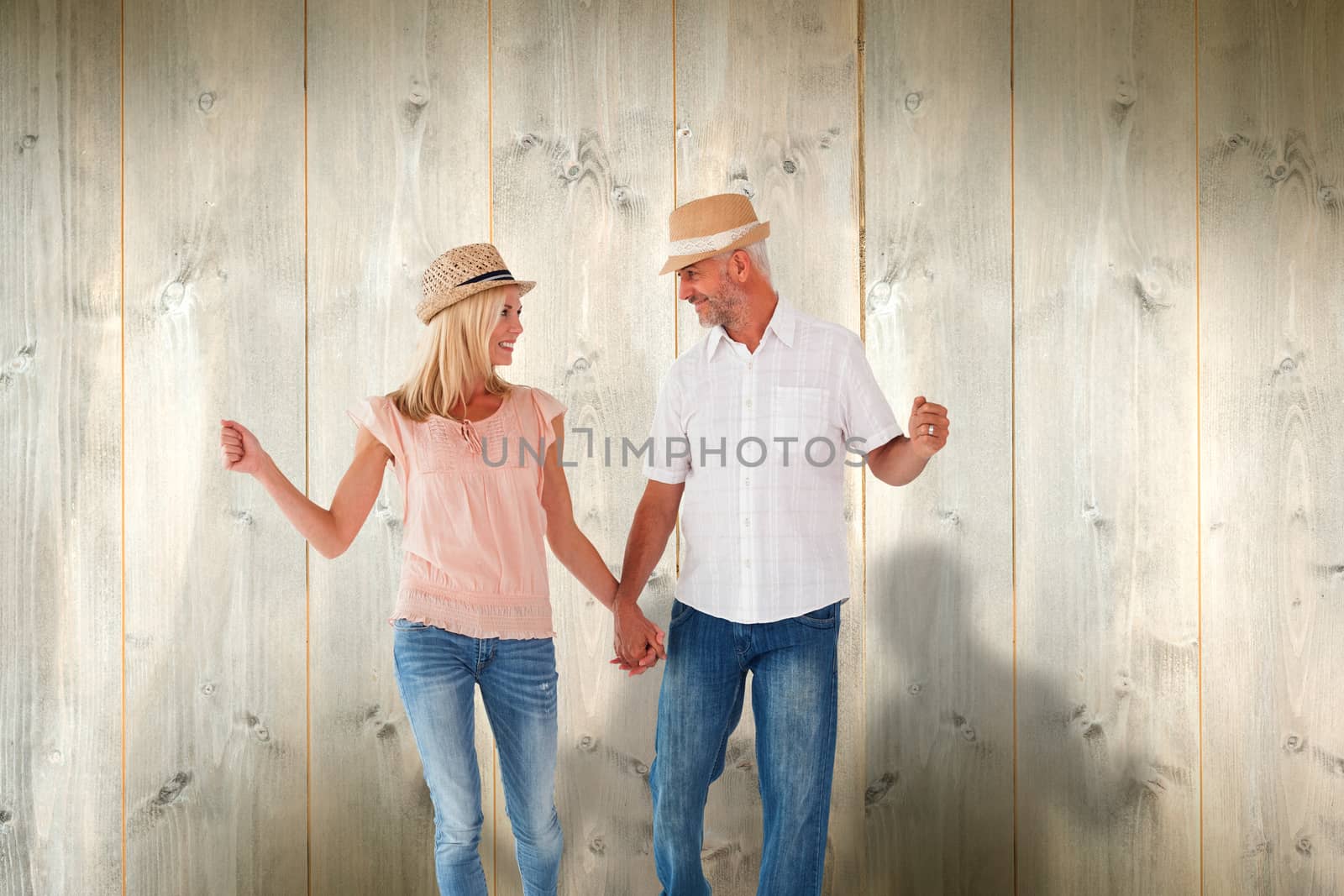 Composite image of happy couple walking holding hands by Wavebreakmedia
