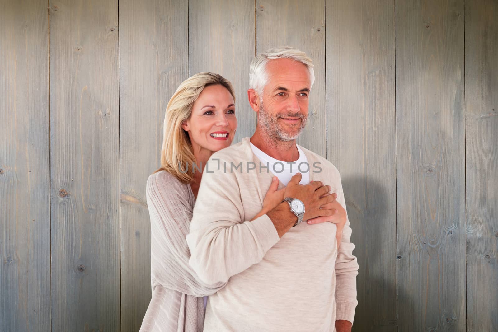 Composite image of happy couple standing and hugging by Wavebreakmedia