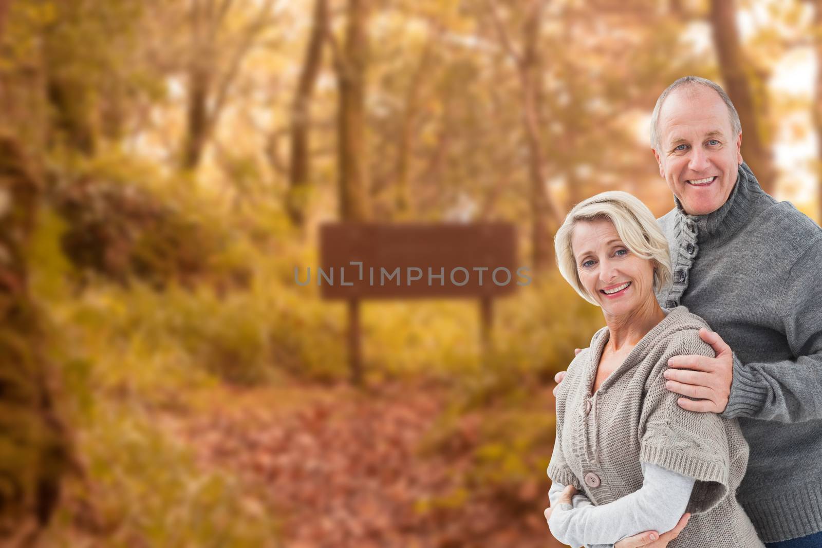 Mature winter couple against tranquil autumn scene in forest