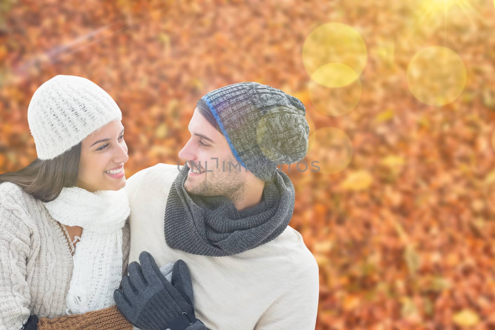 Young winter couple against autumn leaves on the ground