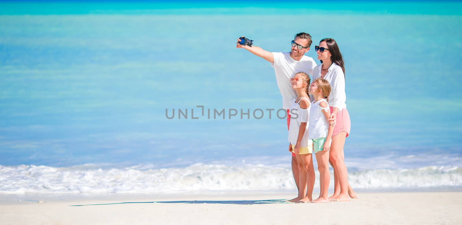 Panorama of happy beautiful family on the beach by travnikovstudio