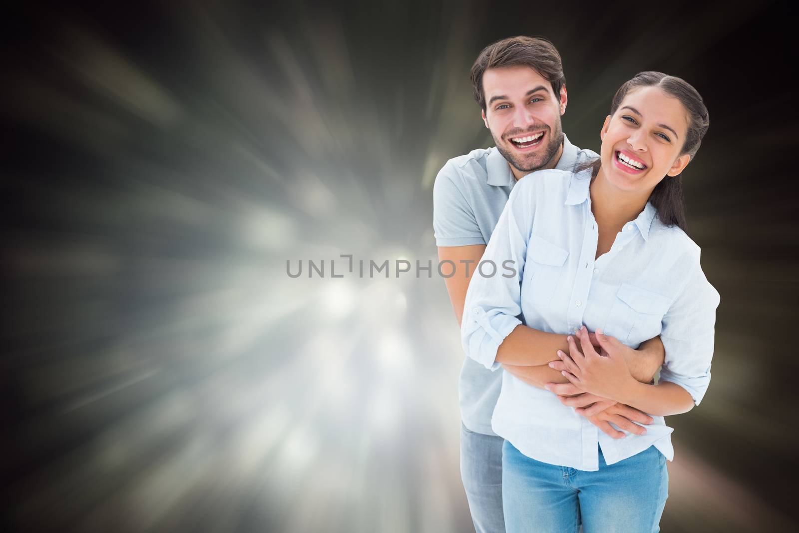 Cute couple hugging and smiling at camera against black abstract light spot design