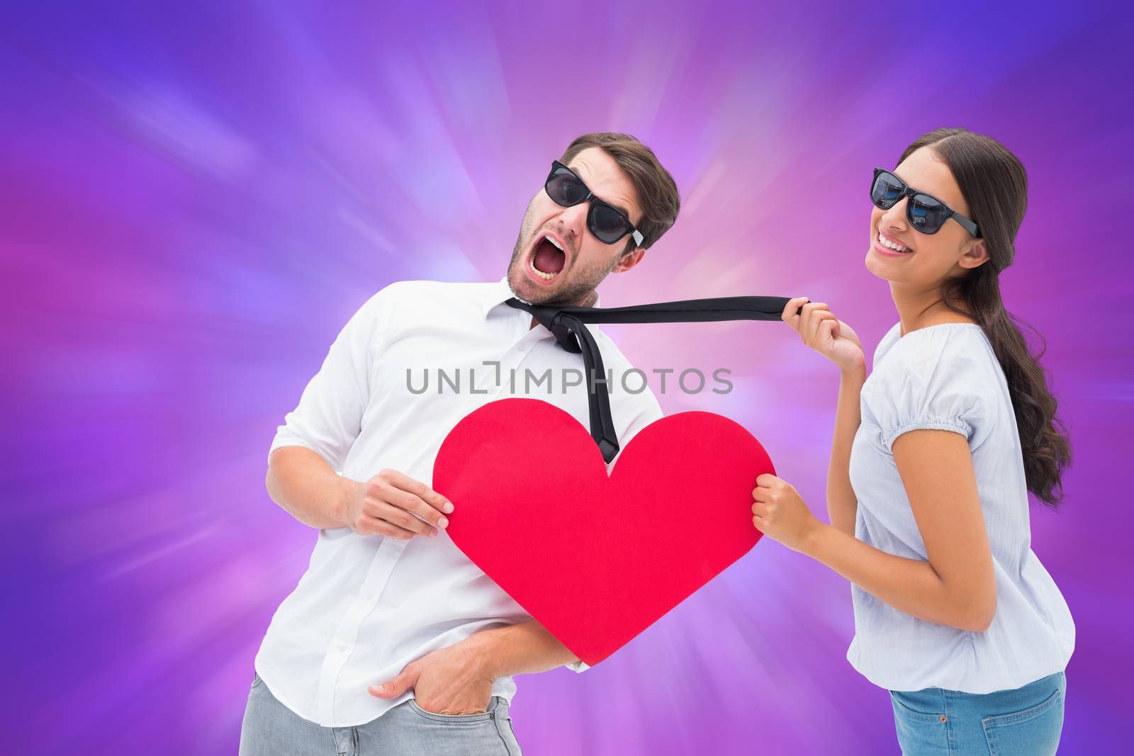 Composite image of brunette pulling her boyfriend by the tie holding heart by Wavebreakmedia