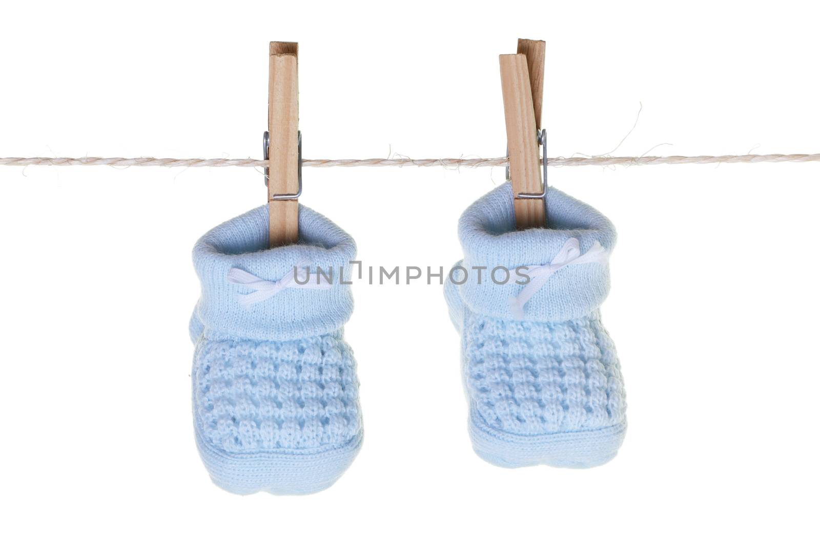 A pair of blue baby booties hanging from washing line with wooden pegs