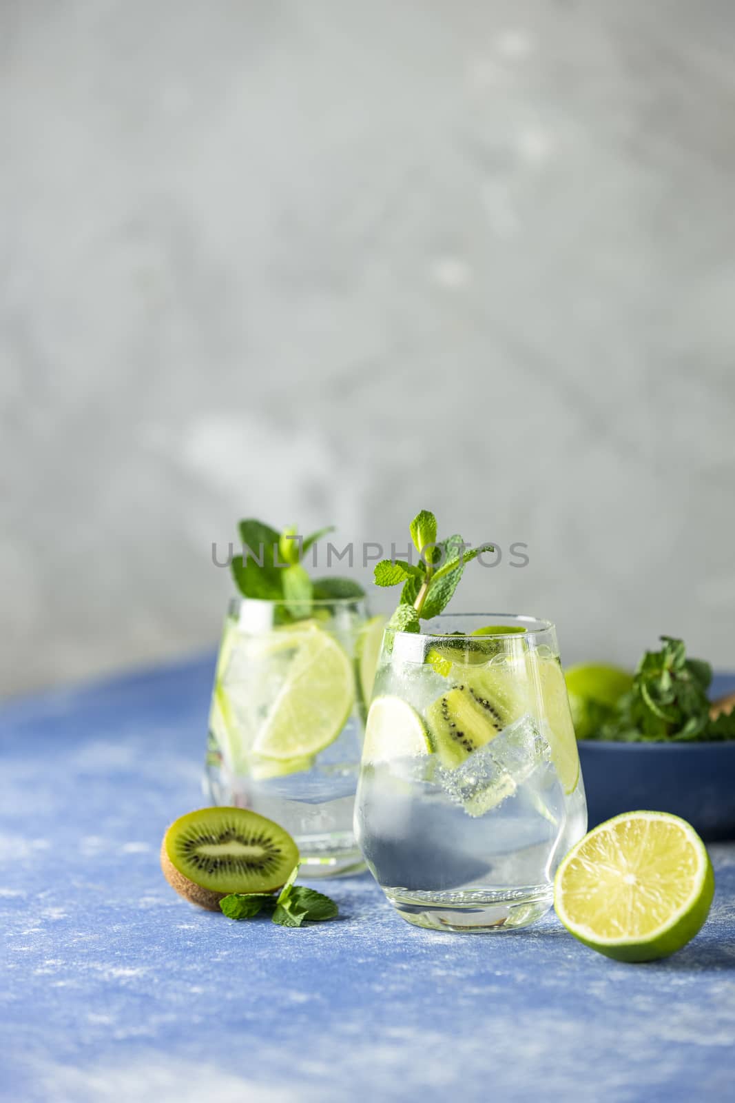 Two detox water or martini tonic cocktail with kiwi, lime, ice and mint. A new kind of mojito with kiwi, lime and mint and of course ice